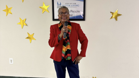 Photo of everlena anderson standing in front of a white wall with gold stars