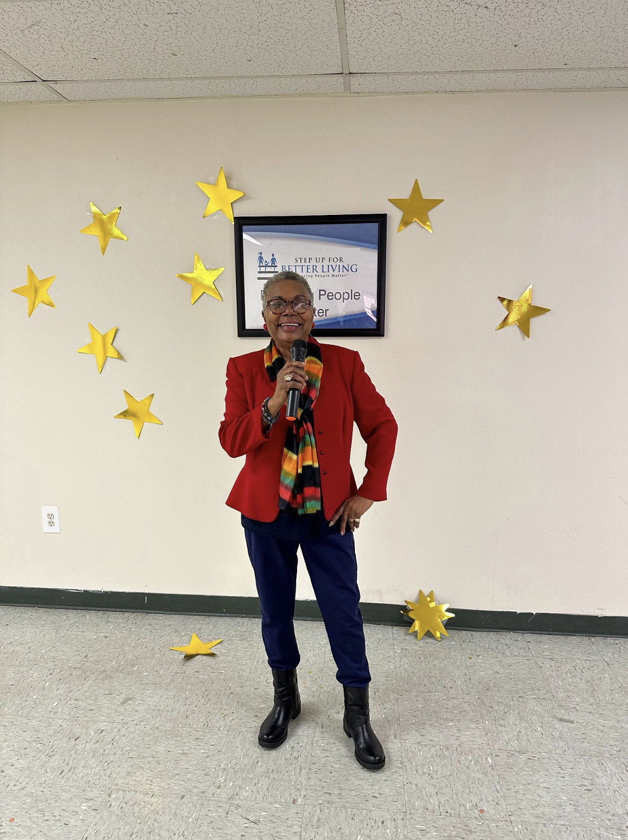 Photo of everlena anderson standing in front of a white wall with gold stars