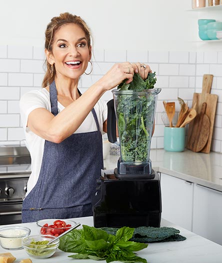 A photo of Joy Bauer using a food processor to make pesto.